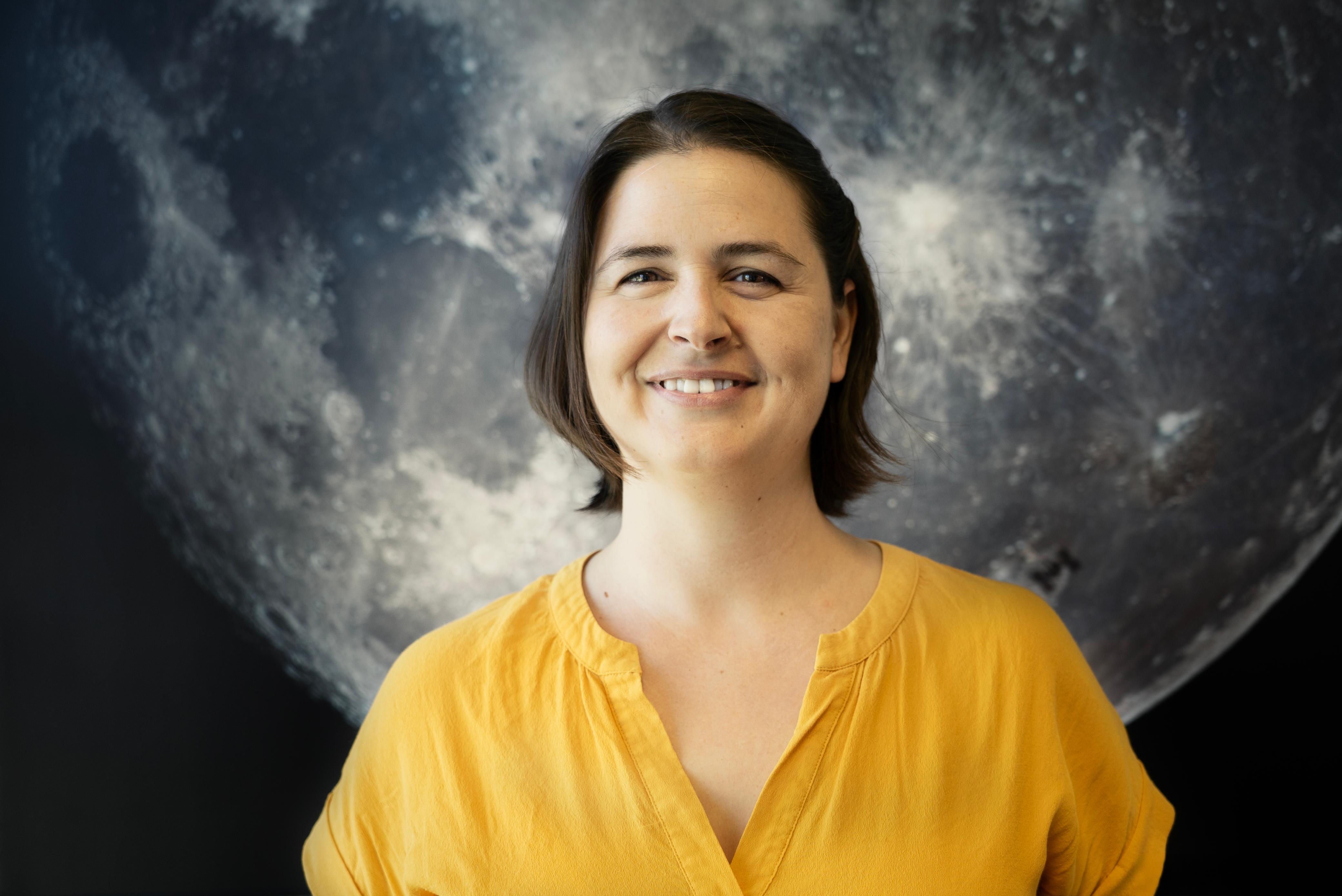 photo of Alejandra in front of an image of the moon